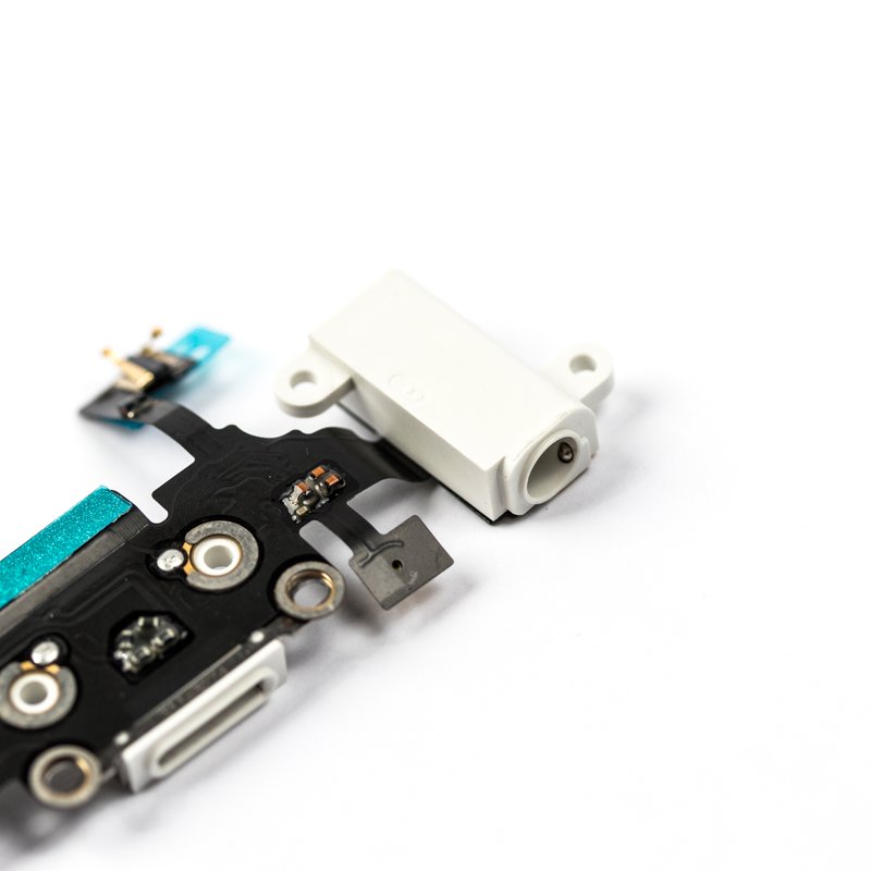 Close-up of the charging port flex cable showing its white Lightning connector, teal tape and gold antenna contacts on a white background.