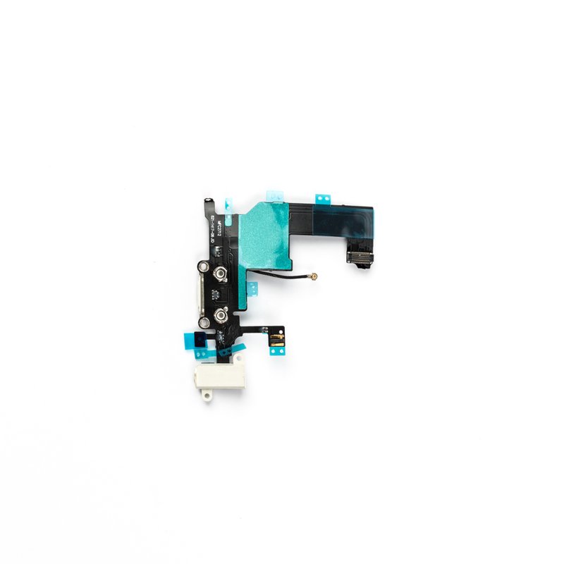 Reverse of the white iPhone 5 charging port flex, showing bright green shielding tape, the white headphone jack, printed part markings and the logic board ribbon connector.