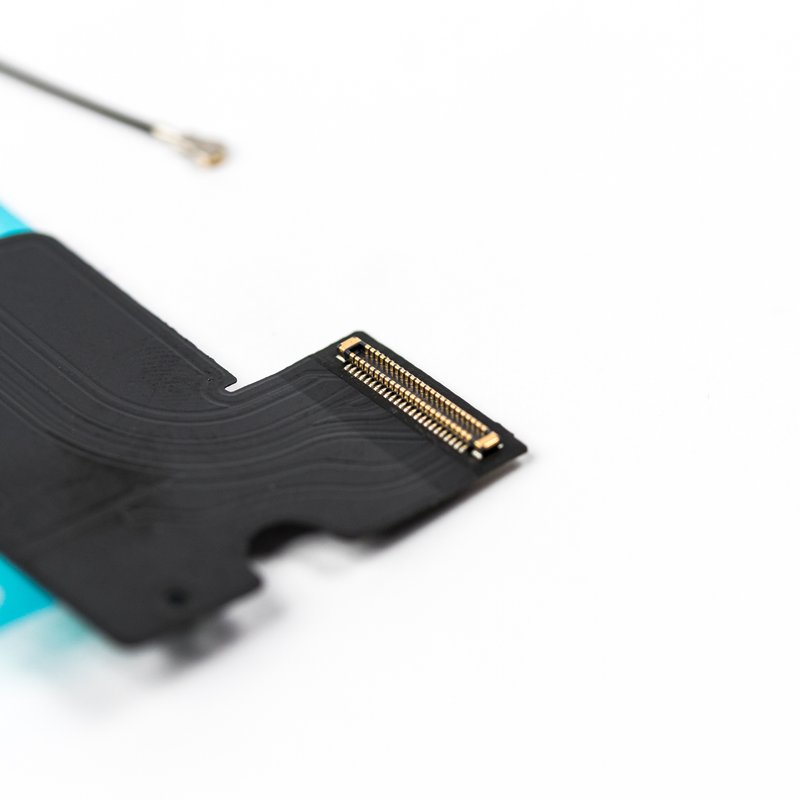Close-up of the iPhone 7 charging flex board-to-board connector, showing its gold contact pins on the black ribbon with the coaxial antenna cable above.