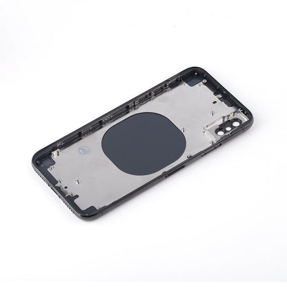 Space grey iPhone X rear housing chassis lying at an angle, inner face up, with the dark wireless charging pad and camera bracket visible.